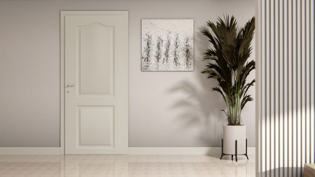 Porte intérieure à panneaux moulurés habillée d'un gris clair mat, avec plante en pot et tableau